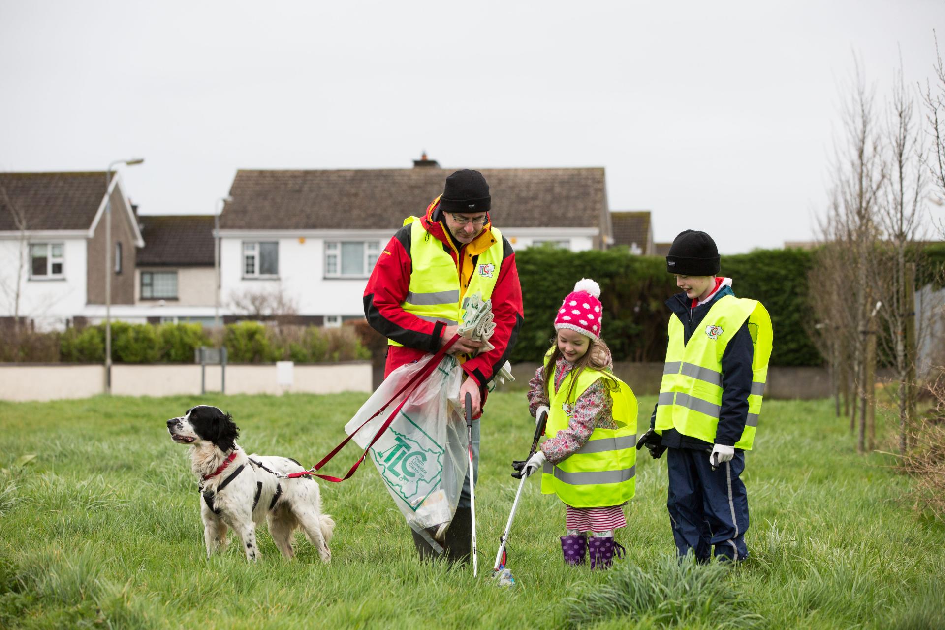 A family tidy up in a grassy area