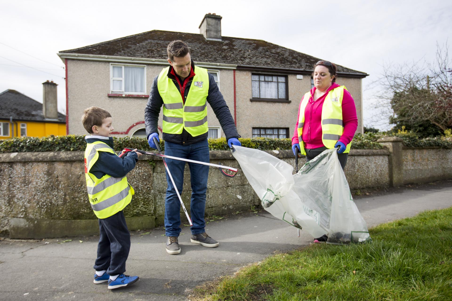 David Wallace helps a young boy and woman clean up at Bellfield Gardens