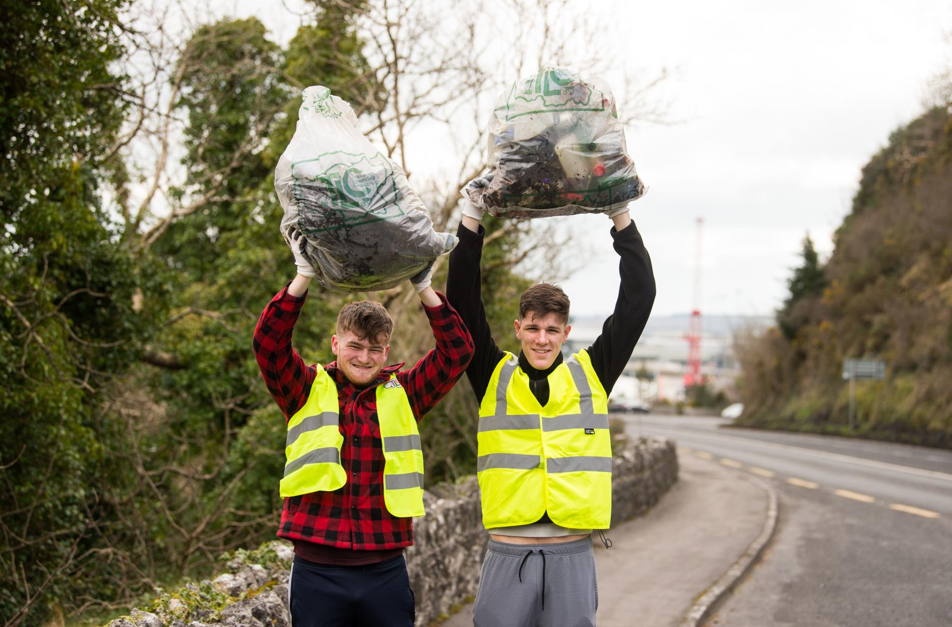 Two young adults with rubbish bags at Foynes