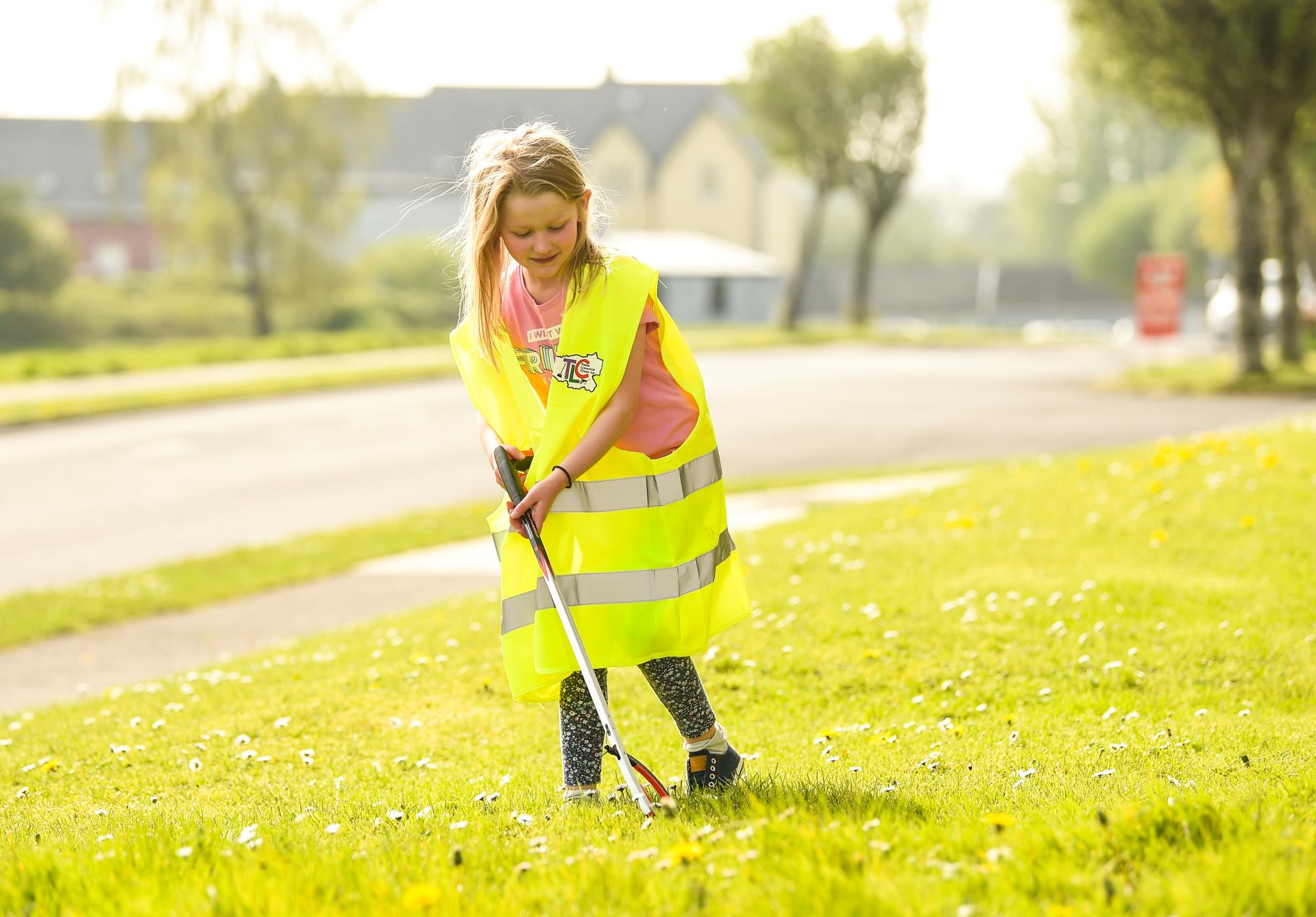 A young girl picks up litter
